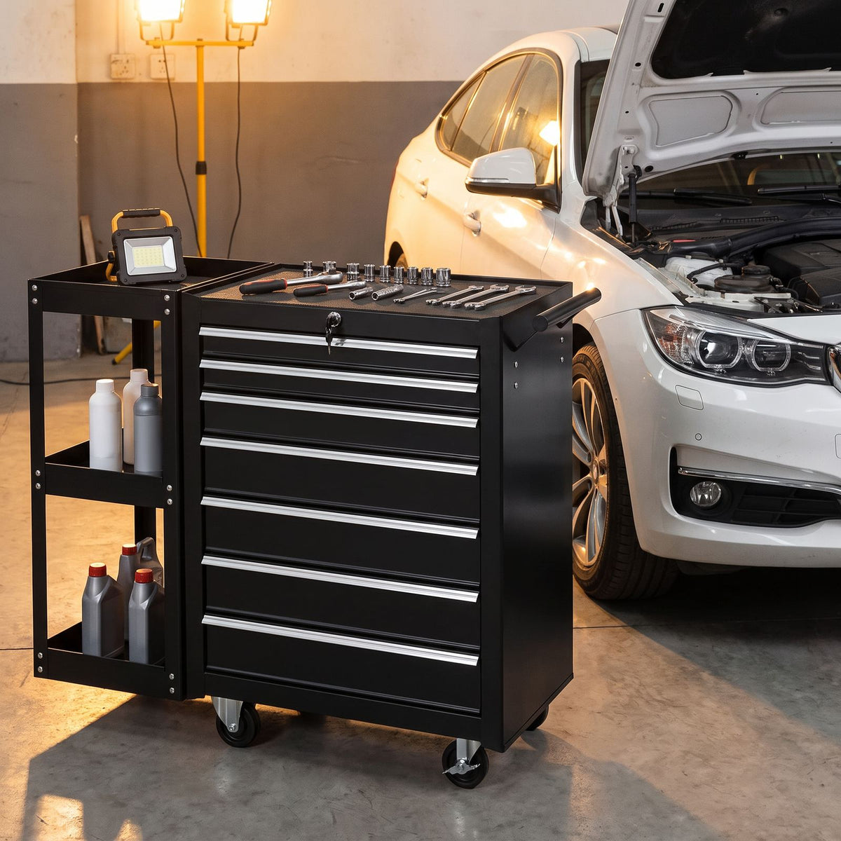 Servante d'atelier avec étagère latérale à côté d'une voiture capot ouvert